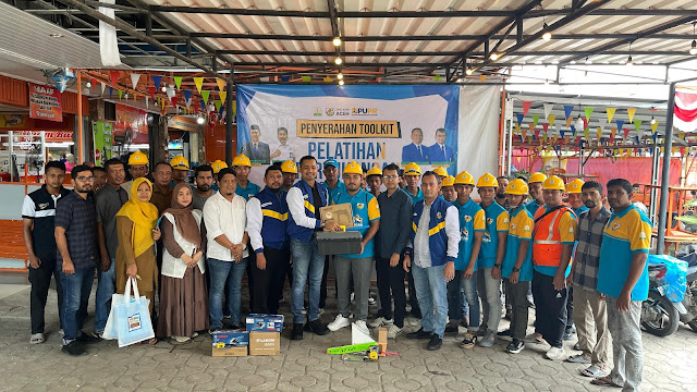 Ketua KNPI Aceh Aulia Rahman secara simbolis menyerahkan tool kit kepada salah satu peserta pelatihan pertukangan yang lulus uji kompetensi, didampingi Kepala BJKW 1 Banda Aceh, Indra Suhada, di Kantor KNPI Aceh, Senin (9/12/2024).