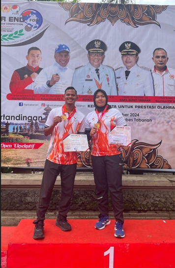 Novi Lidya Isdarianti (kanan) dan M. Muhlis Harliza (kiri) tersenyum bangga usai menerima medali emas pada Kejuaraan Nasional Year End VII Petanque Competition di Tabanan, Bali. Kemenangan ini menjadi kebanggaan bagi Aceh di kancah nasional