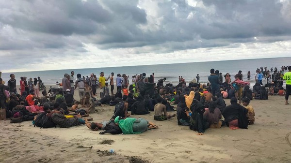 Para pengungsi Rohingya terlihat terdampar di pesisir Aceh setelah menempuh perjalanan laut yang berbahaya. Dalam foto ini, mereka terlihat kelelahan dan terpisah dari kapal kayu yang rusak, yang membawa mereka melintasi perairan. Keadaan mereka kini menjadi sorotan, dengan upaya penyelamatan dan penanganan darurat oleh pihak berwenang serta organisasi internasional seperti UNHCR dan IOM.