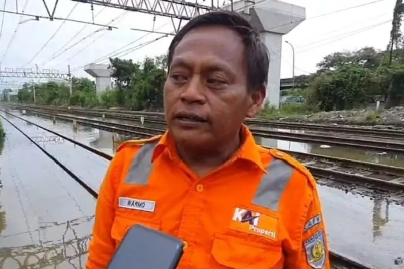 Petugas Jaga Lintasan (PJL) tengah mengantisipasi banjir rob dengan meletakkan batu kerikil di samping rel kereta agar air tidak menggenangi jalur KRL di sekitar Jakarta International Stadium (JIS)