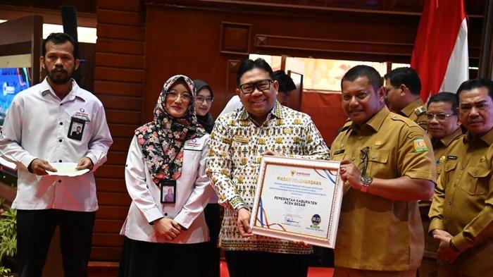 Plt Sekda Aceh Besar, Bahrul Jamil, menerima penghargaan Predikat Kepatuhan Pelayanan Publik Tahun 2024 dari Ombudsman RI di Anjong Mon Mata, Banda Aceh, Selasa (21/1/2025)