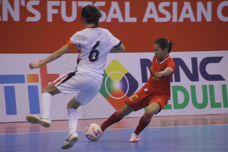 Pertandingan sengit antara Indonesia dan lawan di Piala Asia Futsal Putri 2025, di mana pemain Indonesia berjuang untuk merebut bola dengan penuh semangat.