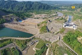 Bendungan Rukoh di Kabupaten Pidie, Aceh, tampak megah dengan latar perbukitan hijau. Bendungan ini memiliki kapasitas tampung 128 juta m³ dan dirancang untuk mengairi lahan irigasi, mengurangi potensi banjir, serta mendukung ketahanan pangan dan energi di wilayah Aceh.
