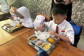  Pelaksanaan Program Makan Bergizi Gratis di SDN Bangka 01 Pagi, Jakarta Selatan, di mana siswa-siswa menerima makanan bergizi seperti nasi putih, ayam goreng mentega, tempe orek, tumis kacang panjang, dan buah pepaya. Foto ini menggambarkan suasana kegiatan yang berlangsung di sekolah sebagai bagian dari upaya pemerintah untuk memastikan anak-anak mendapatkan asupan gizi yang baik
