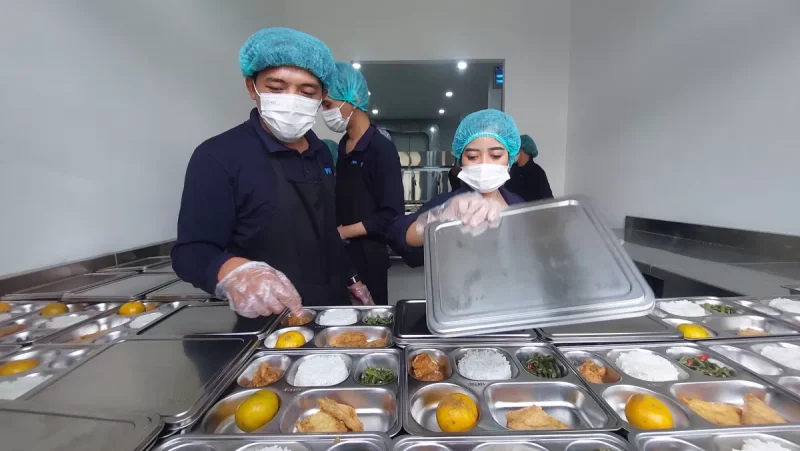 Petugas dapur umum tengah menyiapkan paket makan bergizi untuk disalurkan kepada penerima manfaat Program Makan Bergizi Gratis (MBG), yang dirancang untuk membantu mengurangi angka stunting dan mendukung ekonomi lokal melalui pemanfaatan sumber daya setempat