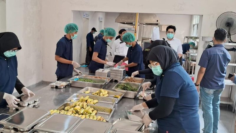 Para petugas di SPPG Khusus Lanud Halim Perdana Kusuma tengah menyiapkan paket makan bergizi gratis untuk didistribusikan kepada ribuan siswa di hari pertama pelaksanaan program MBG, Senin (6/1/2025)
