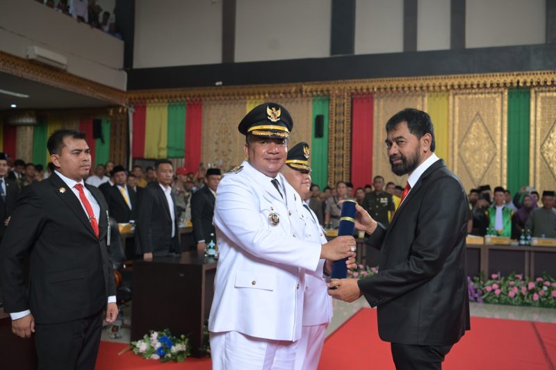 Gubernur Muzakir Manaf menyerahkan penghargaan kepada salah satu tokoh masyarakat dalam acara resmi di Aceh Tenggara. Suasana penuh harapan ini menggambarkan komitmen pemerintah untuk memperkuat kolaborasi dalam mengatasi masalah banjir yang melanda daerah tersebut.