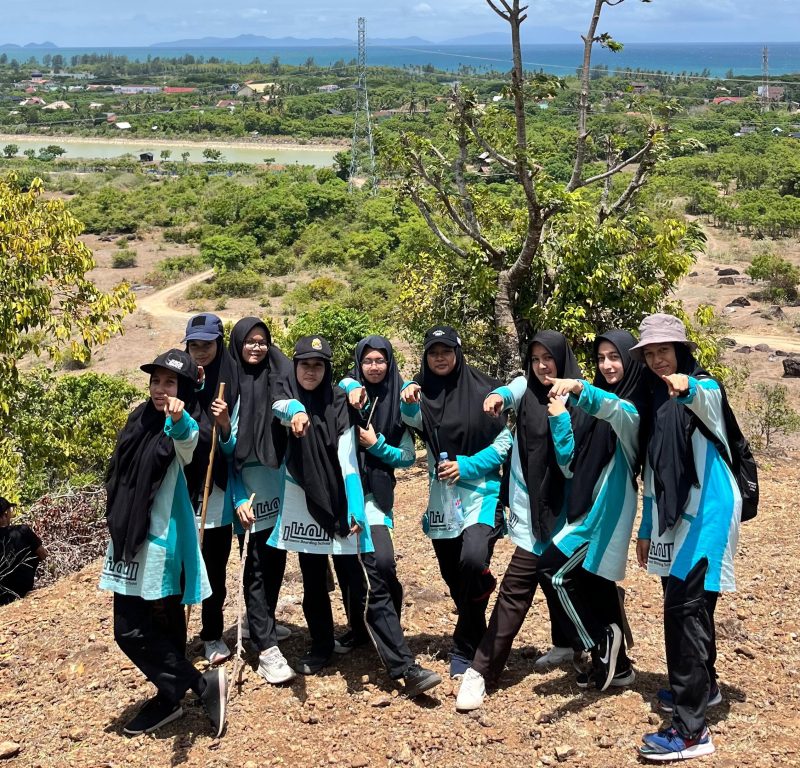 “Salah satu grup santriwati Al-Manar berpose ceria dengan latar keindahan laut dari ketinggian Bukit Tiongkok. Momen ini menjadi bukti semangat mereka menikmati hiking sekaligus mensyukuri panorama alam ciptaan Allah.”